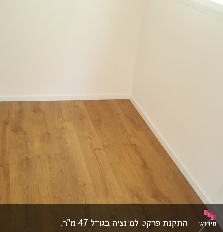 רצפת פרקט עץ בחדר עם קירות לבנים